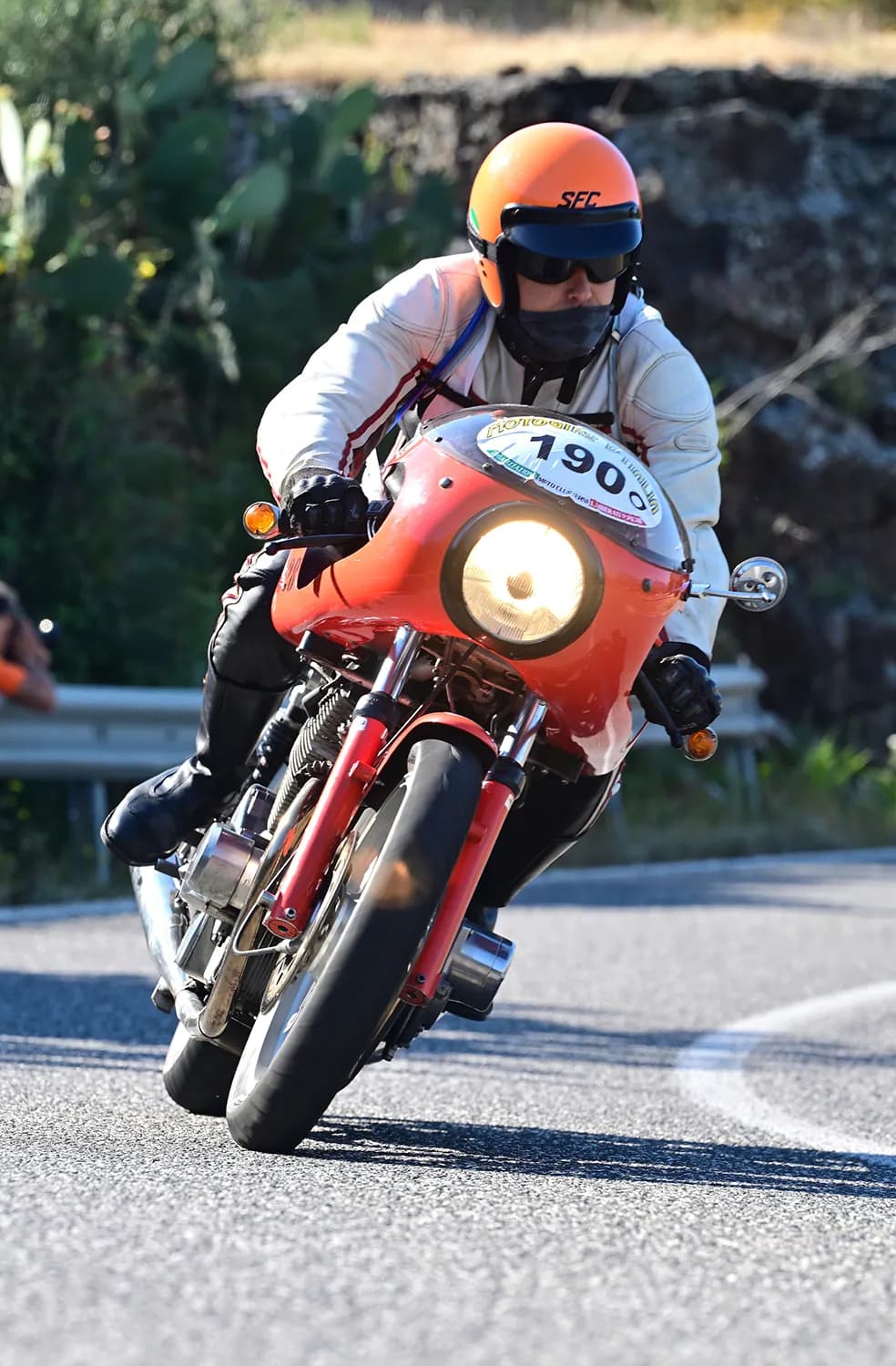 Partecipante con casco jet in azione su moto d'epoca