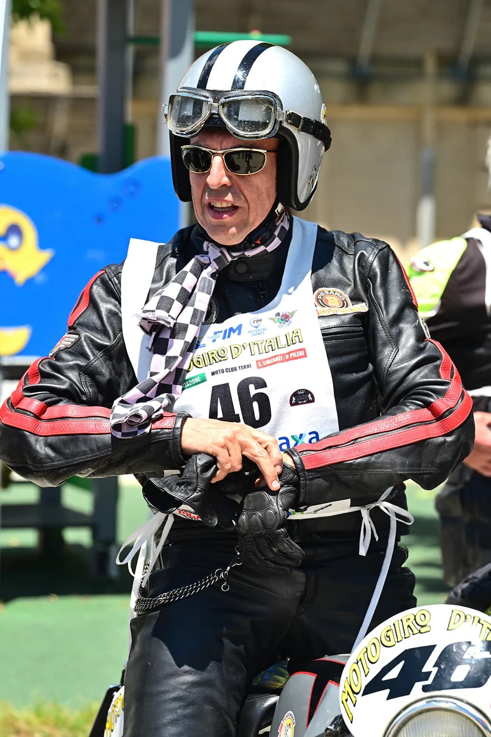 Vespa d'epoca in testa a un gruppo di moto storiche in salita