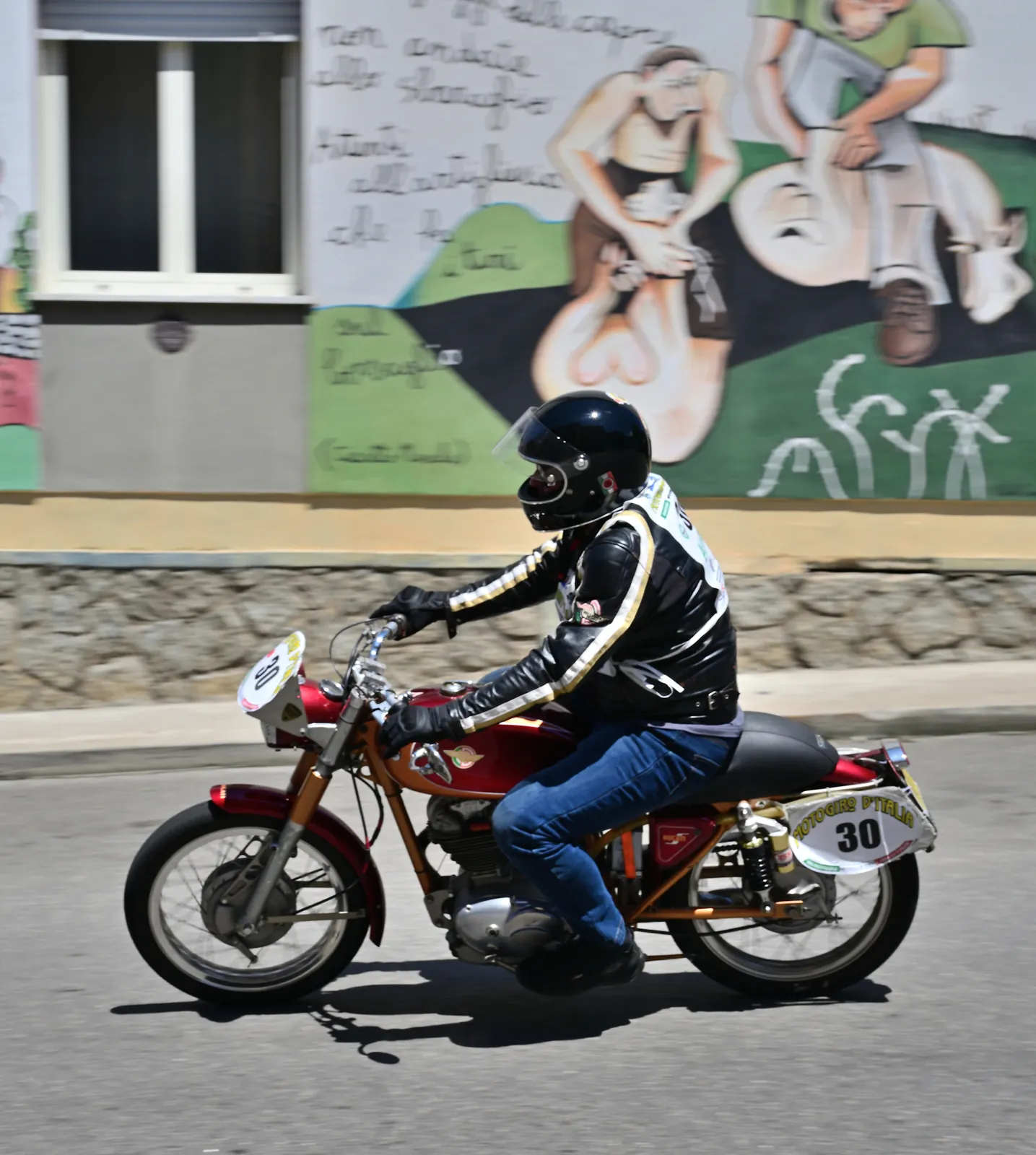 Moto storica in piega davanti al centro storico di Bosa