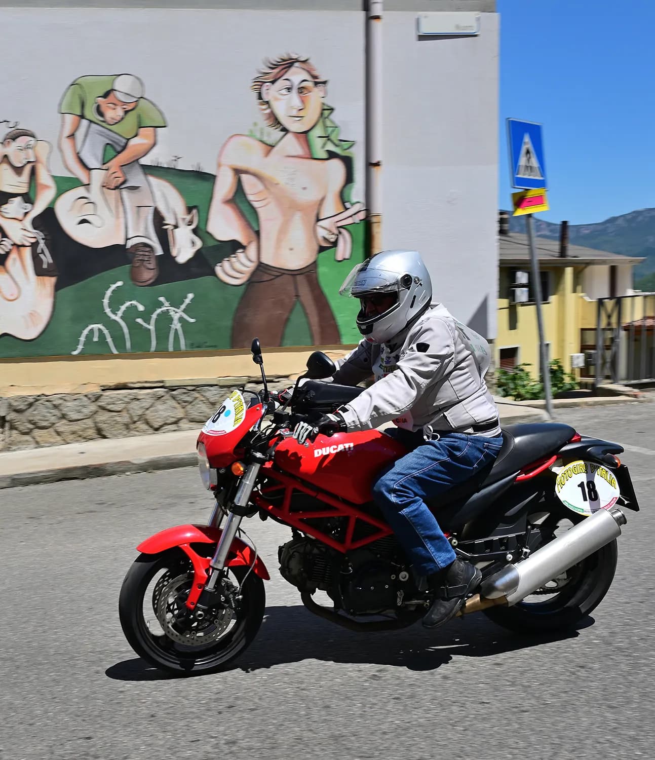 Cafe racer arancione in piega su strada di montagna