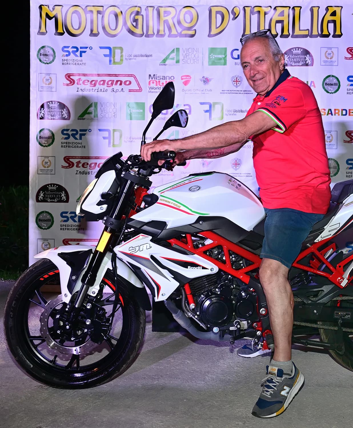 Motociclista saluta lungo il percorso di tappa
