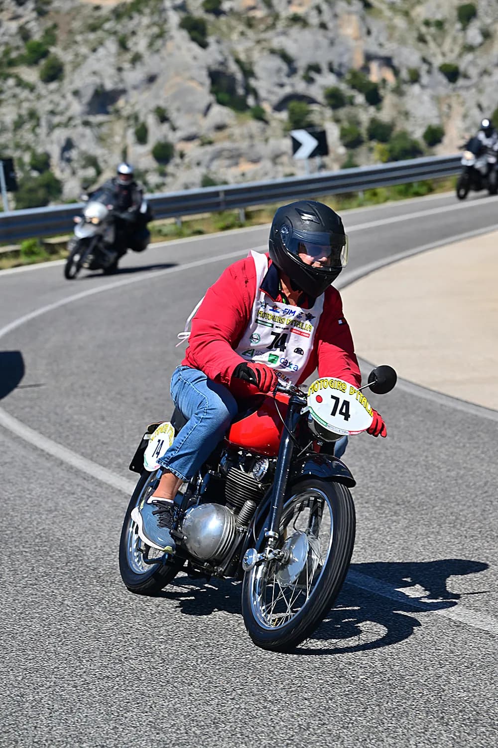 Motociclista con moto storica lungo il percorso