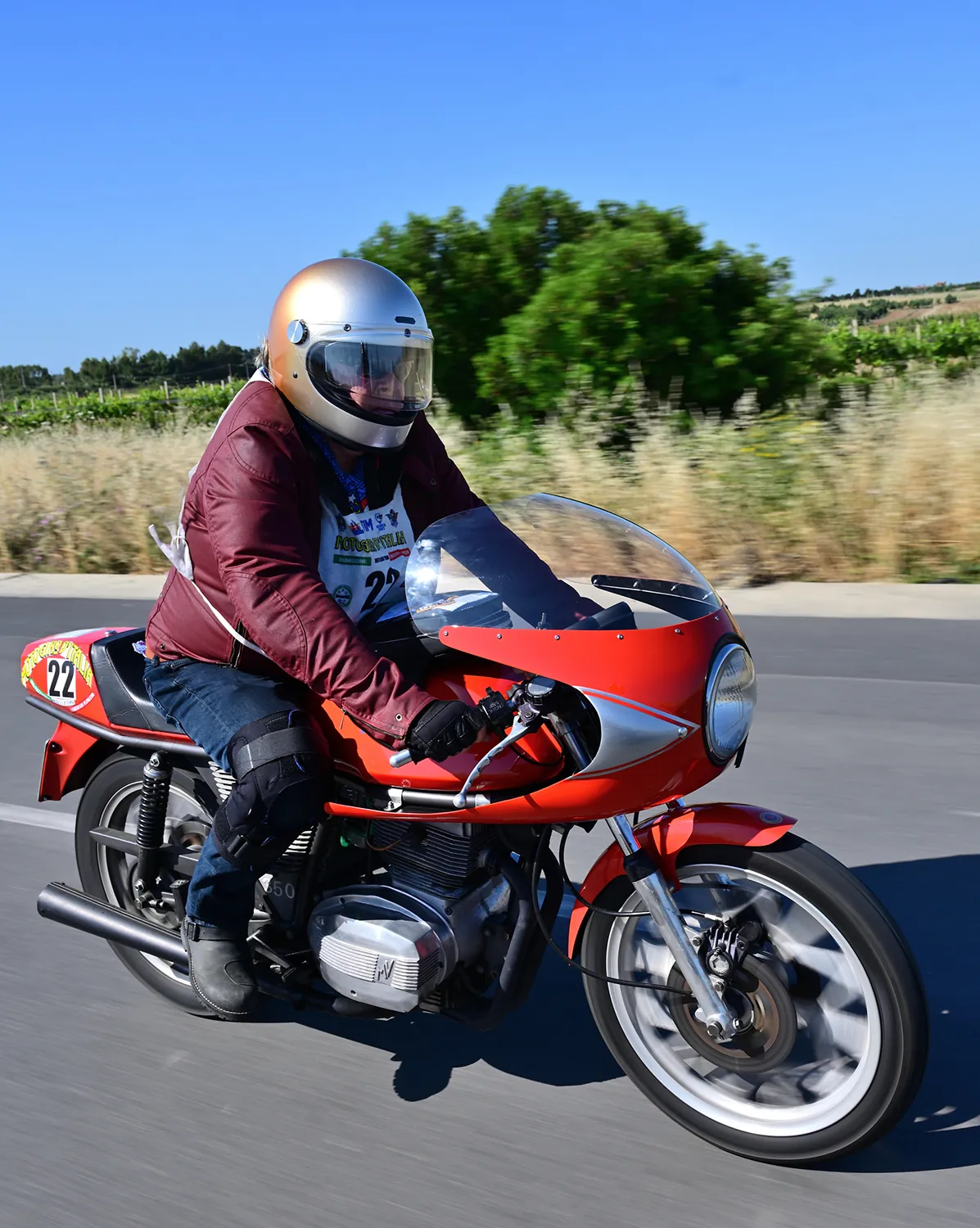Moto storica in piega tra le curve di montagna