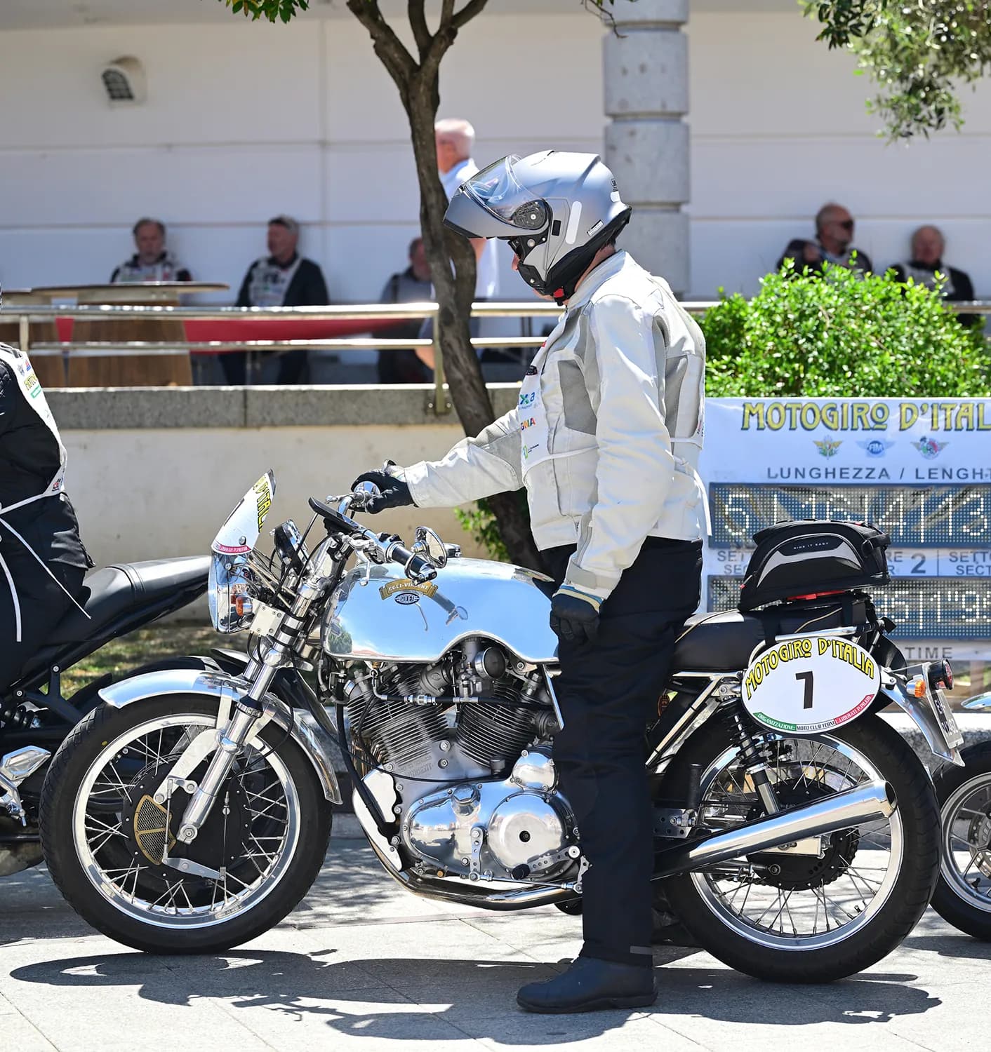 Moto storica al controllo tecnico con il cartello di tappa